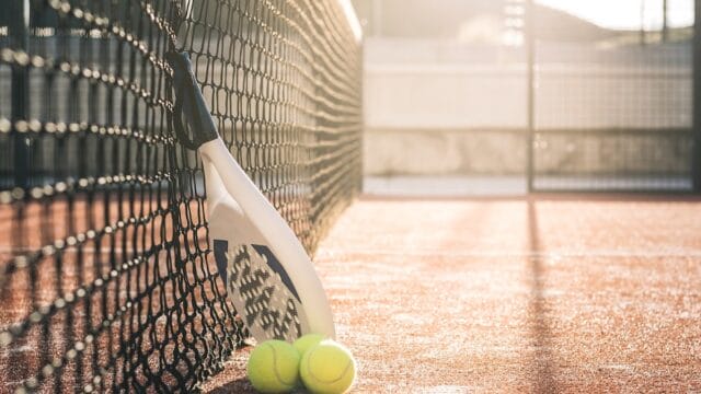 Padel blade racket resting on the net